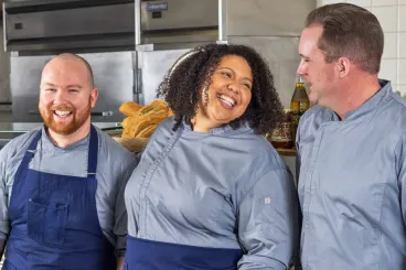 three chefs laughing in the kitchen
